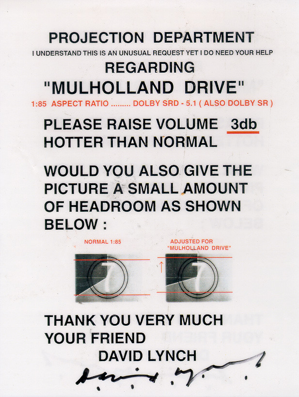 Aviso em formato de pôster tipográfico, dirigido ao departamento de projeção, sobre o filme Mulholland Drive. Assinado à mão por David Lynch, o documento pede que o volume seja aumentado em 3dB acima do normal e que a imagem receba um pequeno headroom extra em relação ao enquadramento padrão 1:85, com um diagrama comparativo ilustrando o ajuste. O tom é direto e pessoal, abrindo com I understand this is an unusual request yet I do need your help e fechando com Your friend, David Lynch.