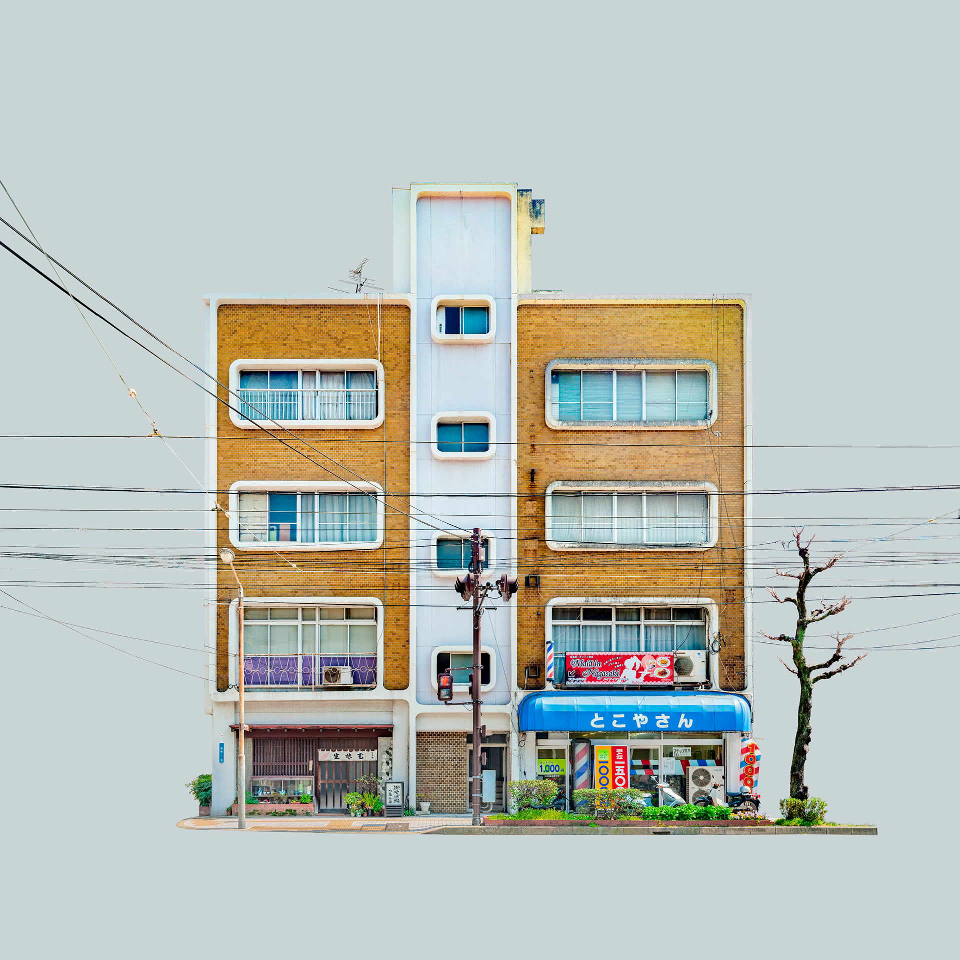 Fachada de prédio residencial de tijolos amarelos com uma faixa central branca e janelas arredondadas. No térreo, uma barbearia com toldo azul e totem giratório, cercada por fios elétricos, isolada sobre fundo cinza-azulado.
